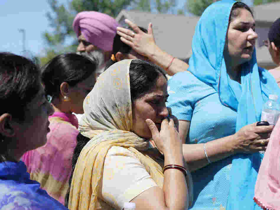 Bystanders wait outside the scene of the shooting.