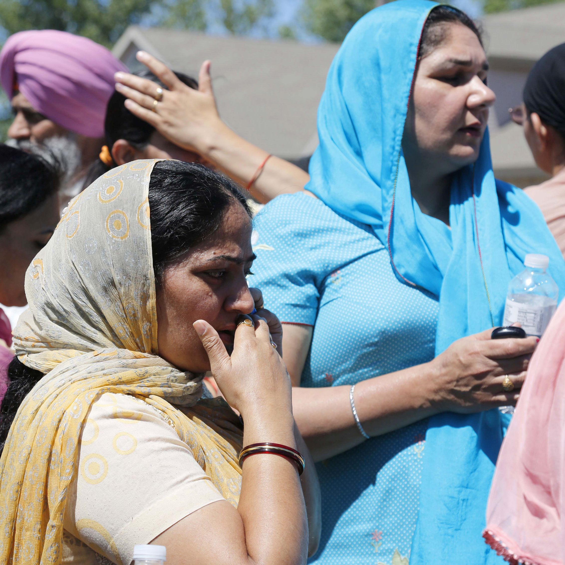 Bystanders wait outside the scene of the shooting.