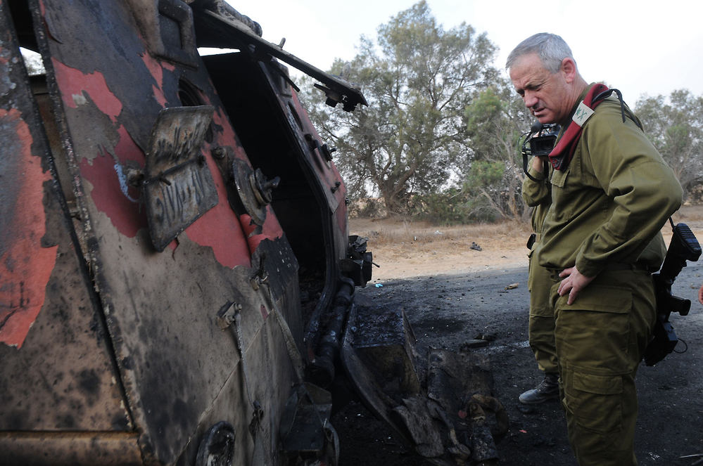 A photo released by the Israeli army shows Israeli chief of staff Lieutenant General Benny Gantz inspecting a burnt vehicle near the Kerem Shalom border crossing after unidentified gunmen crossed into Israel from Egypt.