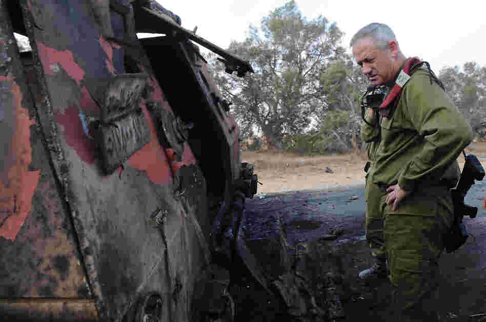 A photo released by the Israeli army shows Israeli chief of staff Lieutenant General Benny Gantz inspecting a burnt vehicle near the Kerem Shalom border crossing after unidentified gunmen crossed into Israel from Egypt.