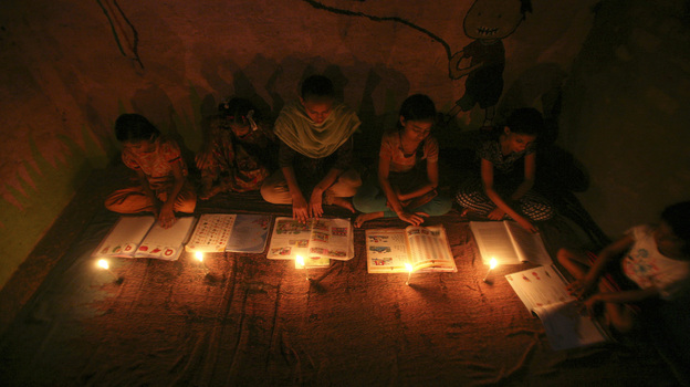 Muslim girls study by candlelight inside a religious school in Noida, near New Delhi, on July 31. The collapse of three regional power grids last week caused a massive power outage that blacked out more than half of India.