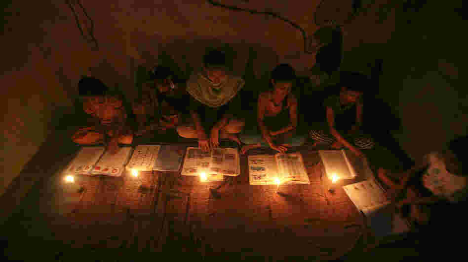 Muslim girls study by candlelight inside a religious school in Noida, near New Delhi, on July 31. The collapse of three regional power grids last week caused a massive power outage that blacked out more than half of India.