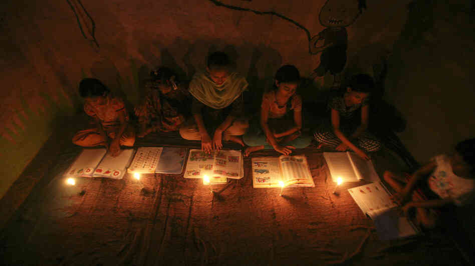 Muslim girls study by candlelight inside a religious school in Noida, near New Delhi, on July 31. The collapse of three regional power grids last week caused a massive power outage that blacked out more than half of India.