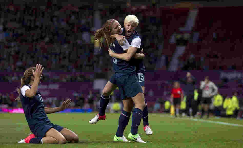 United States' Megan Rapinoe, right, celebrates with teammate Alex Morgan as Tobin Heath slides in on her knees after scoring against Canada during their semifinal women's soccer match at the 2012 London Summer Olympics, Monday.