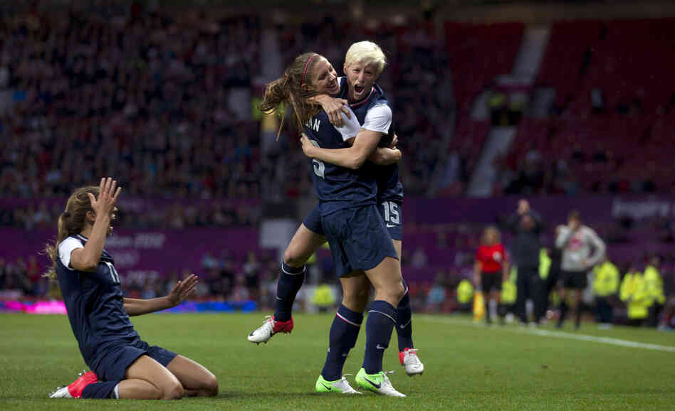 United States' Megan Rapinoe, right, celebrates with teammate Alex Morgan as Tobin Heath slides in on her knees after scoring against Canada during their semifinal women's soccer match at the 2012 London Summer Olympics, Monday.
