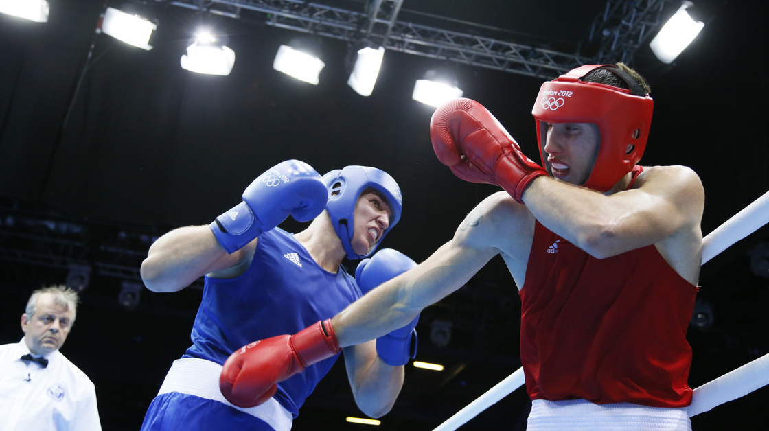 Siarhei Karneyeu of Belarus (in blue) landed most of the punches in the third round of his bout with Teymur Mammadov of Azerbaijan, who wasn't penalized for holding.