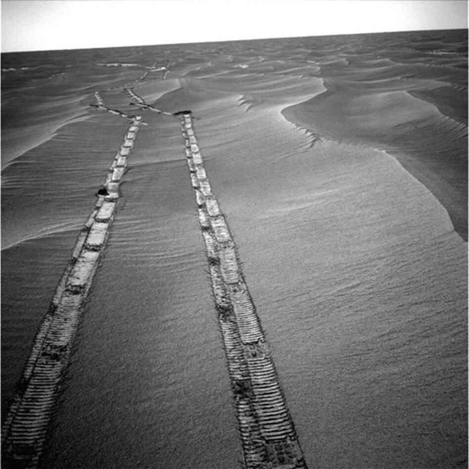 Opportunity used its navigation camera for this view of tracks the rover left on a drive from one end of a sand ripple to another, 2010.