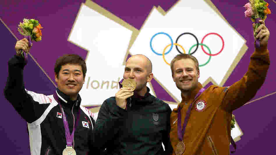 Matthew Emmons of America (right) celebrates his bronze medal, along with Italy's Niccolo Campriani (center) and South Korea's Kim Jonghyun, after the men's 50m rifle 3 positions final.