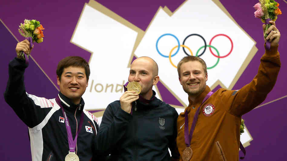 Matthew Emmons of America (right) celebrates his bronze medal, along with Italy's Niccolo Campriani (center) and South Korea's Kim Jonghyun, after the men's 50m rifle 3 positions final.