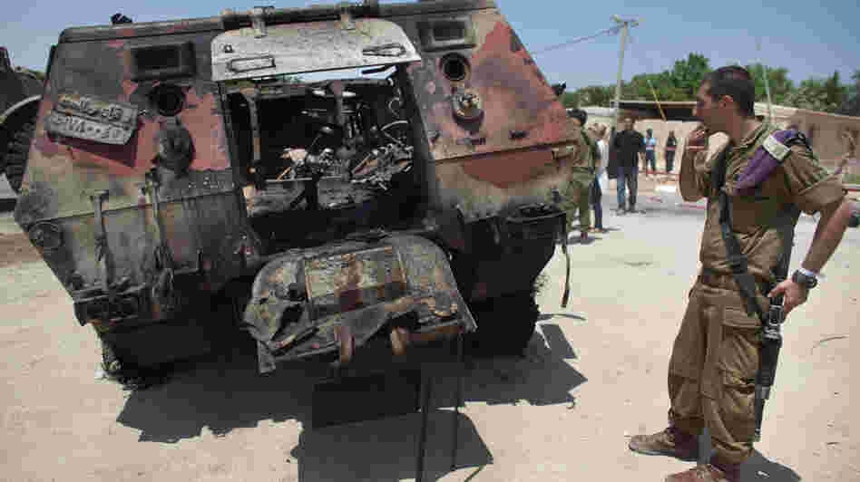 Militants drove two armored vehicles through a security fence into Israel from Egypt on Sunday, leaving 16 Egyptian soldiers dead and destroying two armored vehicles. An Israeli soldier inspects the wreckage of one of the Egyptian military trucks at a base in Kerem Shalom, Israel.
