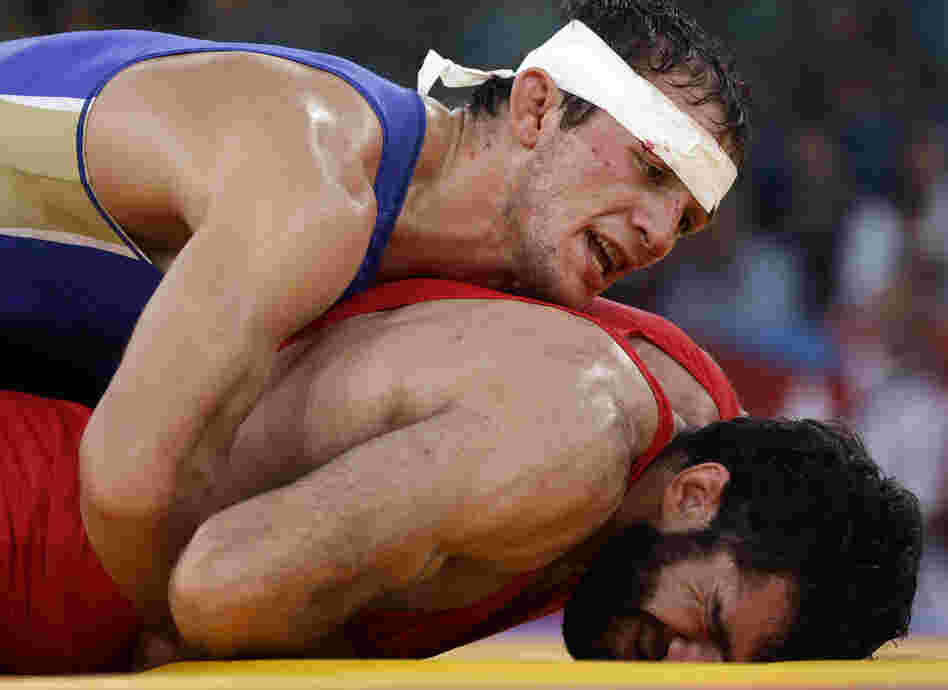 Alan Khugaev of Russia (in blue) competes against Vladimer Gegeshidze of Georgia during the 84kg Greco-Roman wrestling semifinal. Khugaev went on to win gold in the final.