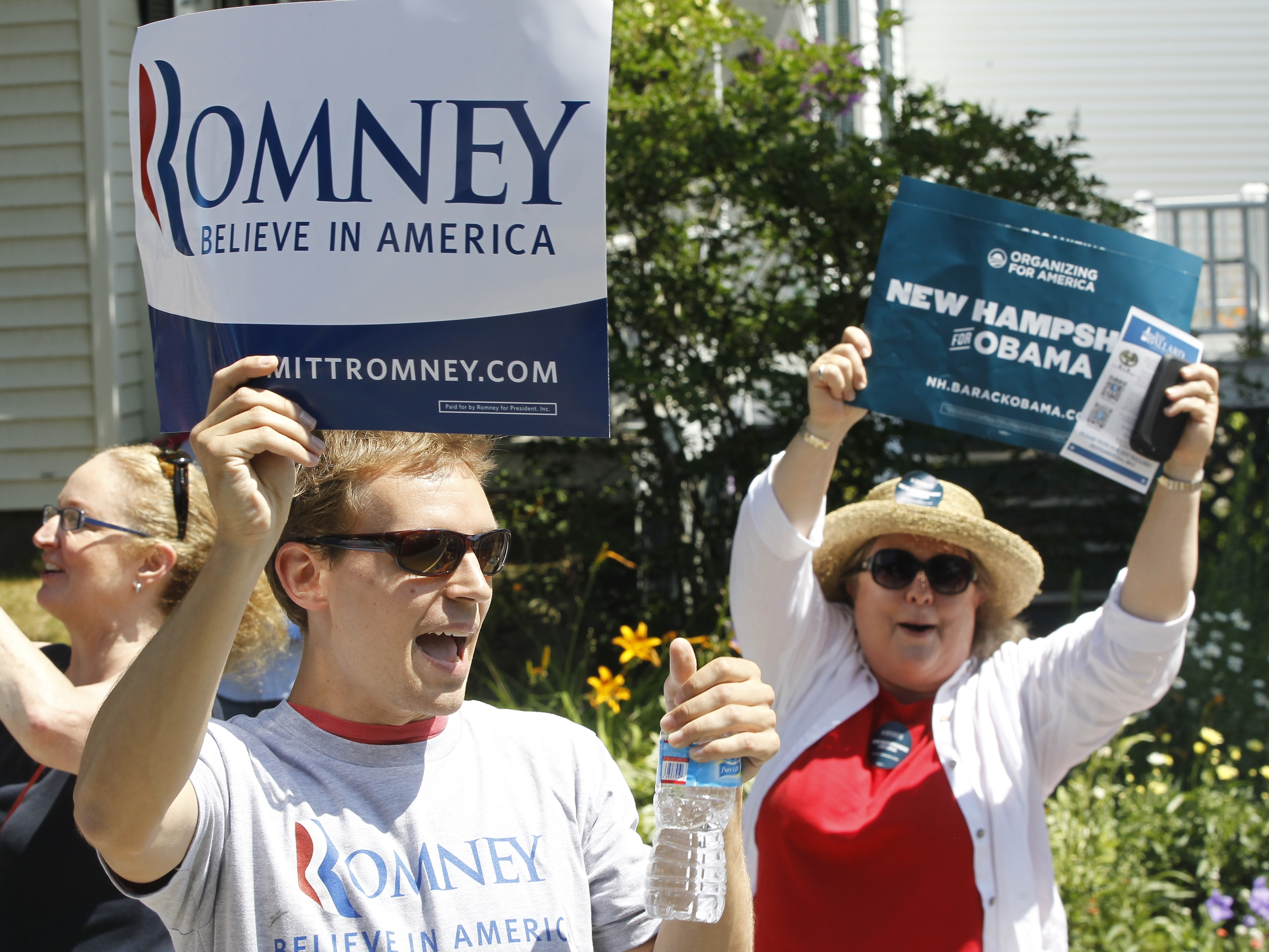Supporters of President Obama shout as Republican presidential candidate Mitt Romney walks in the Fourth of July Parade in Wolfeboro, N.H.