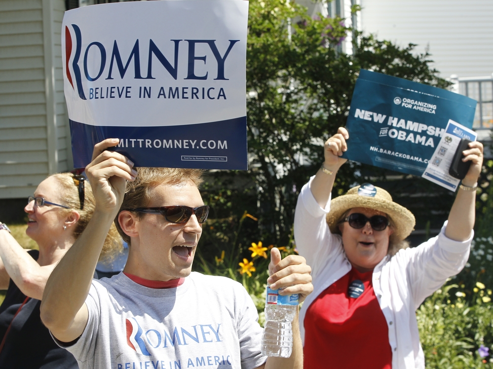 Supporters of President Obama shout as Republican presidential candidate Mitt Romney walks in the Fourth of July Parade in Wolfeboro, N.H.