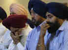 Members of the Sikh Temple of Wisconsin react at a news conference at Oak Creek Centennial church in Oak Creek, Wis. on Monday.