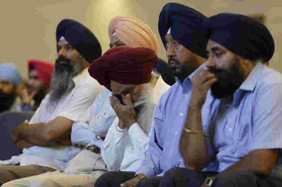 Members of the Sikh Temple of Wisconsin react at a news conference at Oak Creek Centennial church in Oak Creek, Wis. on Monday.