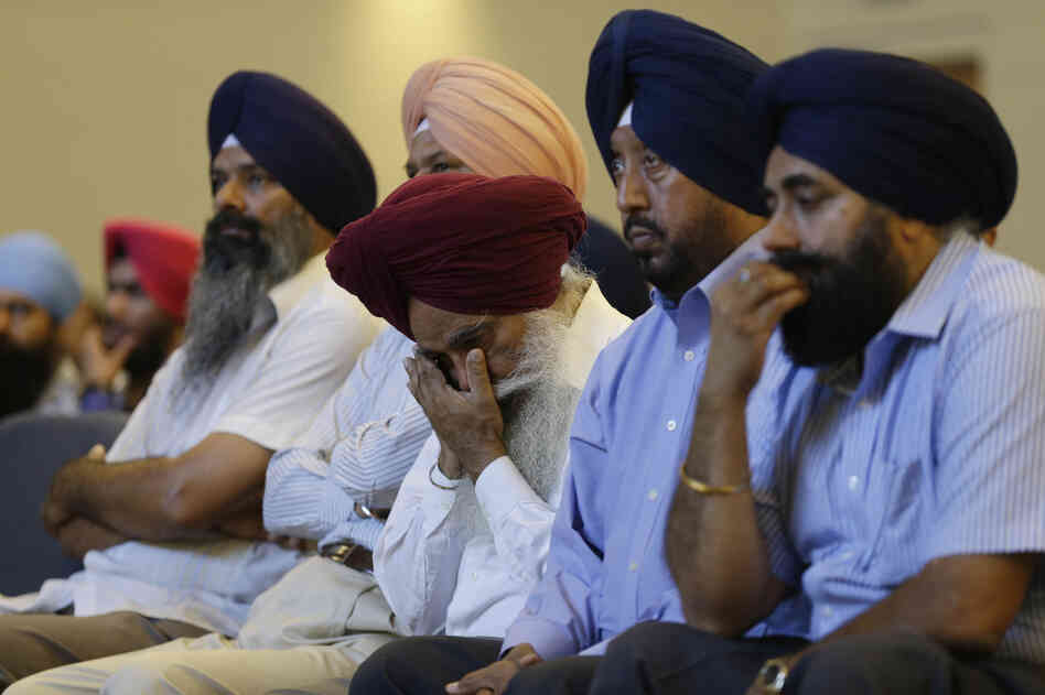 Members of the Sikh Temple of Wisconsin react at a news conference at Oak Creek Centennial church in Oak Creek, Wis. on Monday.