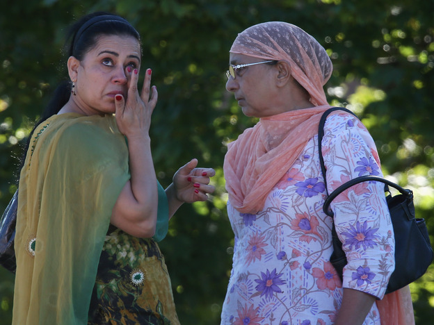 A woman wipes away a tear in front of the Sikh Temple of Wisconsin on Sunday in Oak Creek.