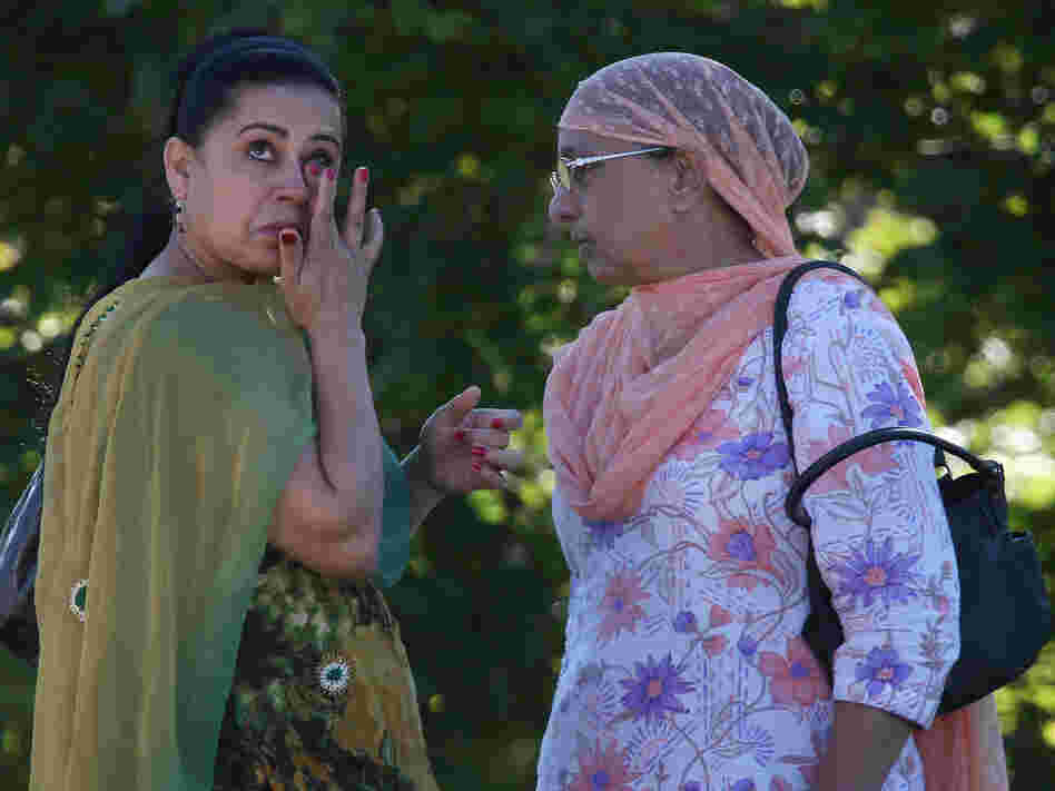 A woman wipes away a tear in front of the Sikh Temple of Wisconsin on Sunday in Oak Creek.