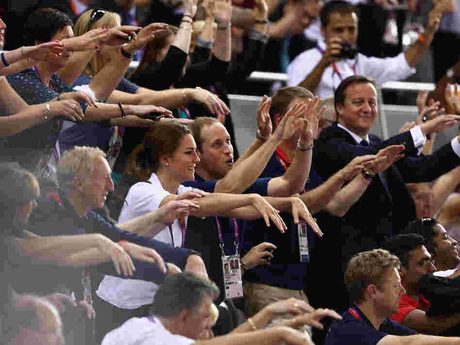 Prince William, his wife, Catherine, and Prime Minister David Cameron take part in the wave as they watch the track cycling at the London Games.