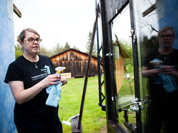 Christine Sheppard, an ornithologist with the American Bird Conservancy, cleans windows before conducting an experiment that will help determine which pane of glass is more bird friendly.