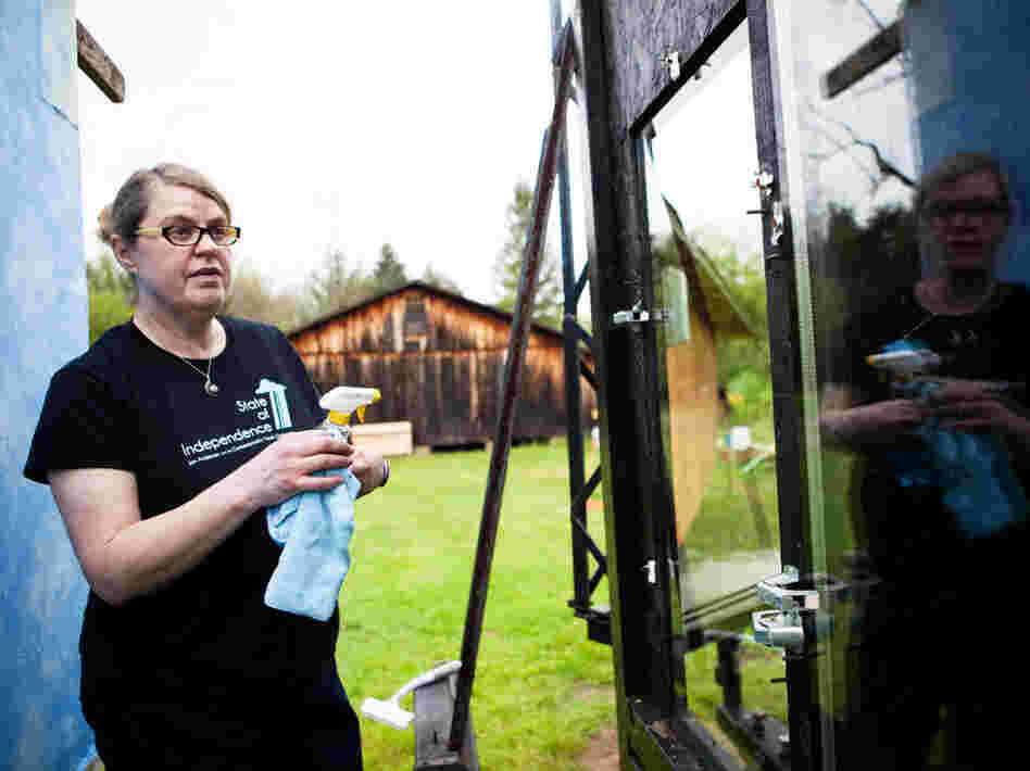 Christine Sheppard, an ornithologist with the American Bird Conservancy, cleans windows before conducting an experiment that will help determine which pane of glass is more bird friendly.