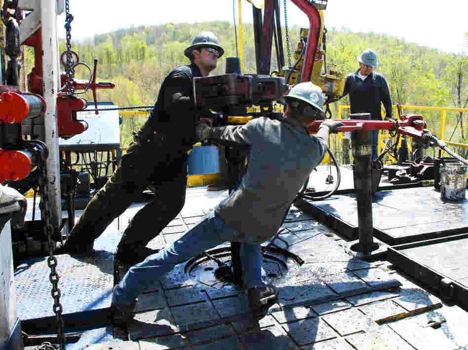 Workers move a section of well casing into place at a Chesapeake Energy natural gas well site near Burlington, Pa., in 2010.
