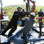 Workers move a section of well casing into place at a Chesapeake Energy natural gas well site near Burlington, Pa., in 2010.