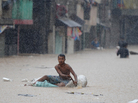 A man paddled an improvised raft along a flooded street in suburban Manila earlier today. A man paddled an improvised raft along a flooded street in suburban Manila earlier today.
