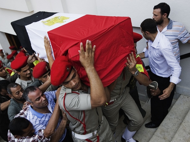 In Cairo on Tuesday, Egyptian Army military policemen carried the coffin of one of the 16 border guards killed during an attack on a crossing post in the northern Sinai on Sunday.