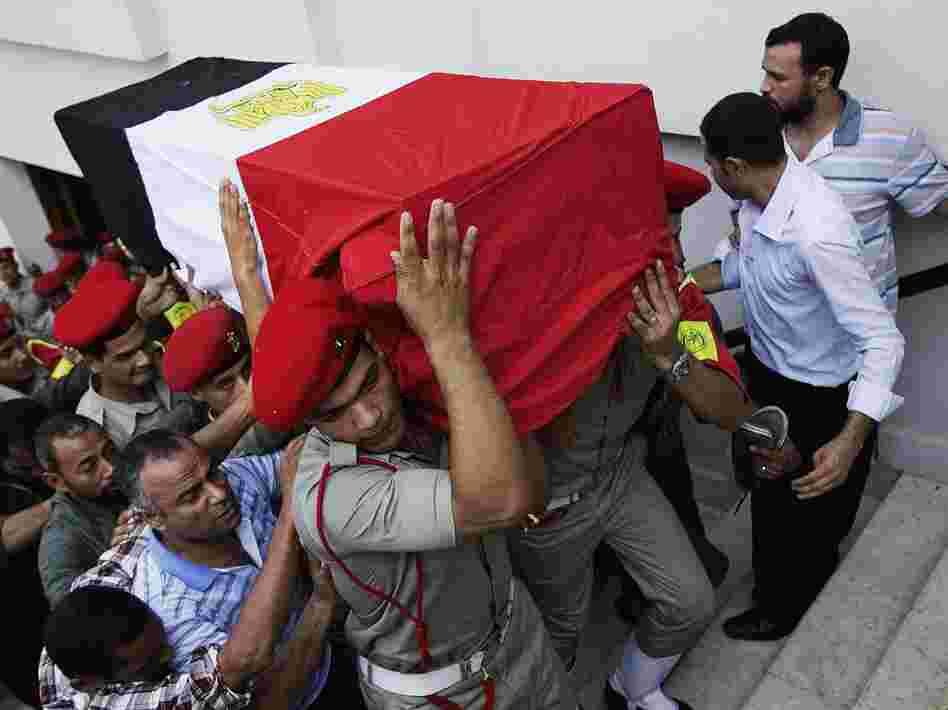 In Cairo on Tuesday, Egyptian Army military policemen carried the coffin of one of the 16 border guards killed during an attack on a crossing post in the northern Sinai on Sunday.
