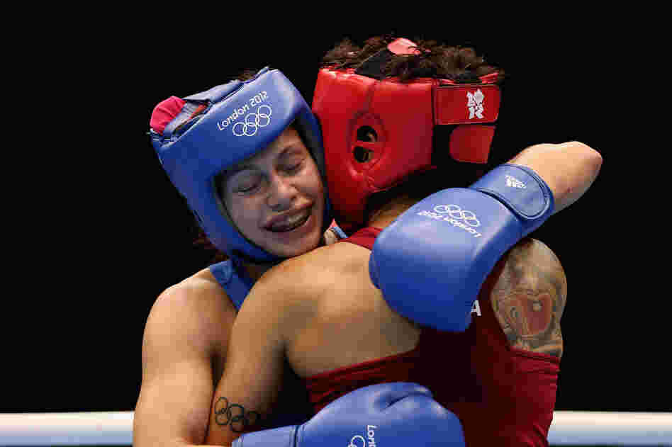 Sofya Ochigava (in blue) of Russia hugs Adriana Araujo of Brazil after their bout during the Women's Light Boxing semifinals on Day 12 of the London Olympic Games. Ochigava won the bout.