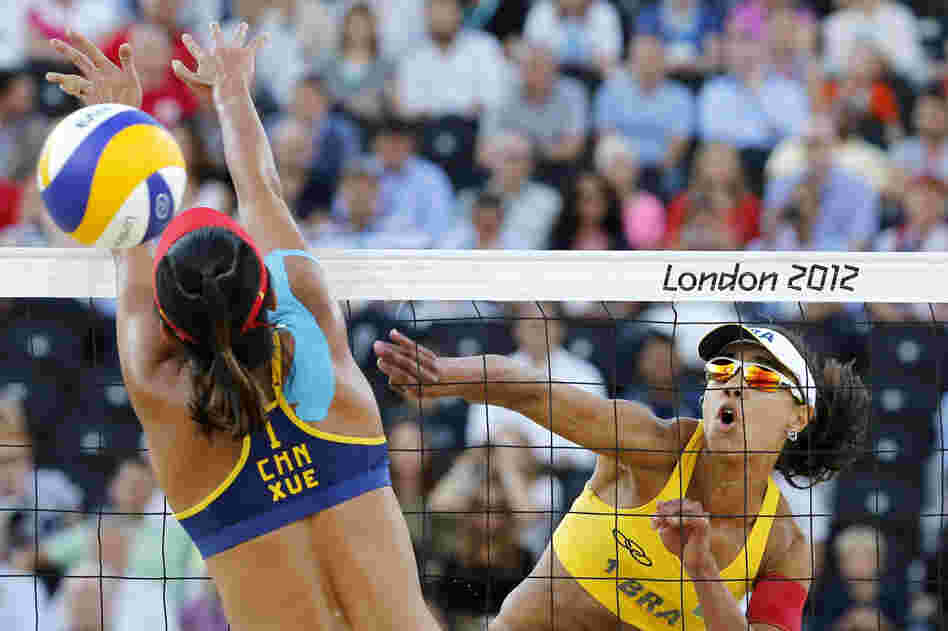 China's Xue Chen (left) blocks a spike by Brazil's Juliana Silva in their women's beach volleyball bronze medal match. Brazil won 2-1.