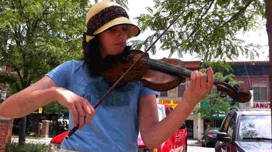 Alexis Dawdy plays her violin on the streets of Lansing, Mich.