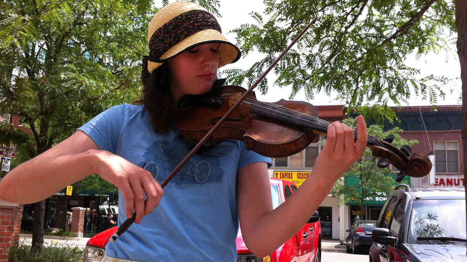 Alexis Dawdy plays her violin on the streets of Lansing, Mich.