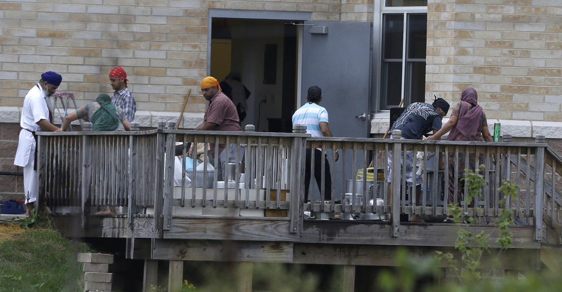 Members of the Sikh temple of Wisconsin wash items as they return for the first time in Oak Creek, Wis.