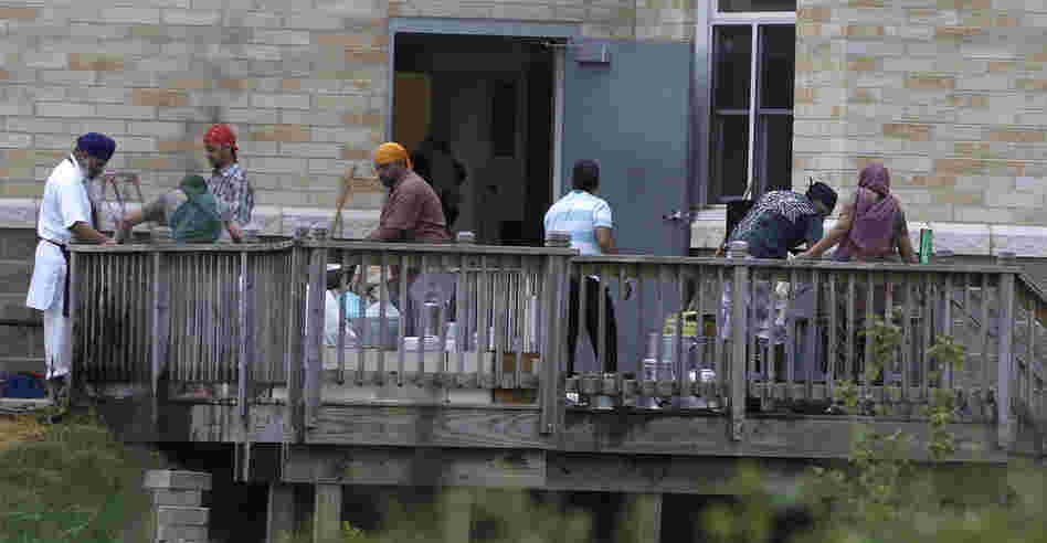 Members of the Sikh temple of Wisconsin wash items as they return for the first time in Oak Creek, Wis.