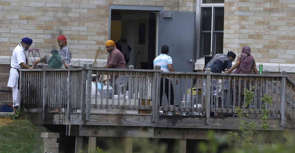 Members of the Sikh temple of Wisconsin wash items as they return for the first time in Oak Creek, Wis.