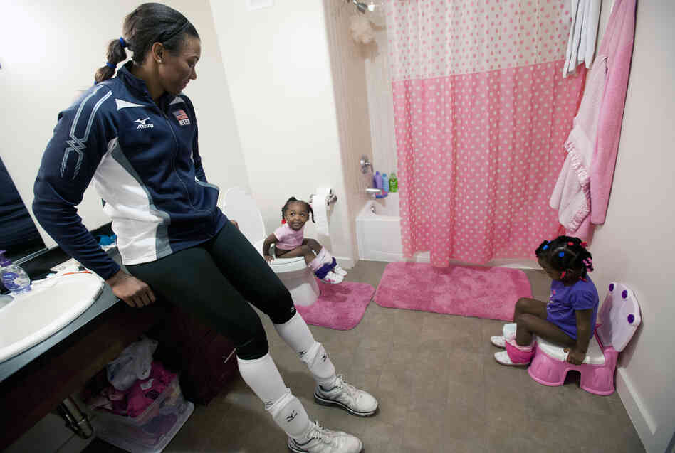 Danielle Scott-Arruda helps her grandniece Madison (left) and daughter Julianne in the bathroom. Scott-Arruda is a volleyball player on the U.S. Olympic team.