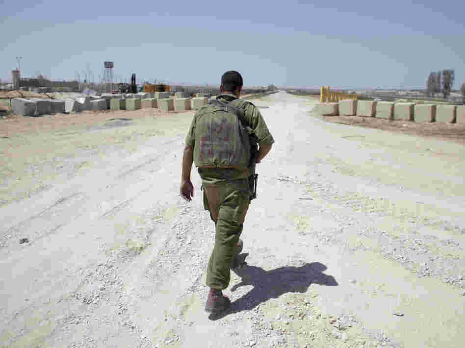 An Israeli soldier walks near the border between Israel and Egypt at the Kerem Shalom border crossing on Wednesday.