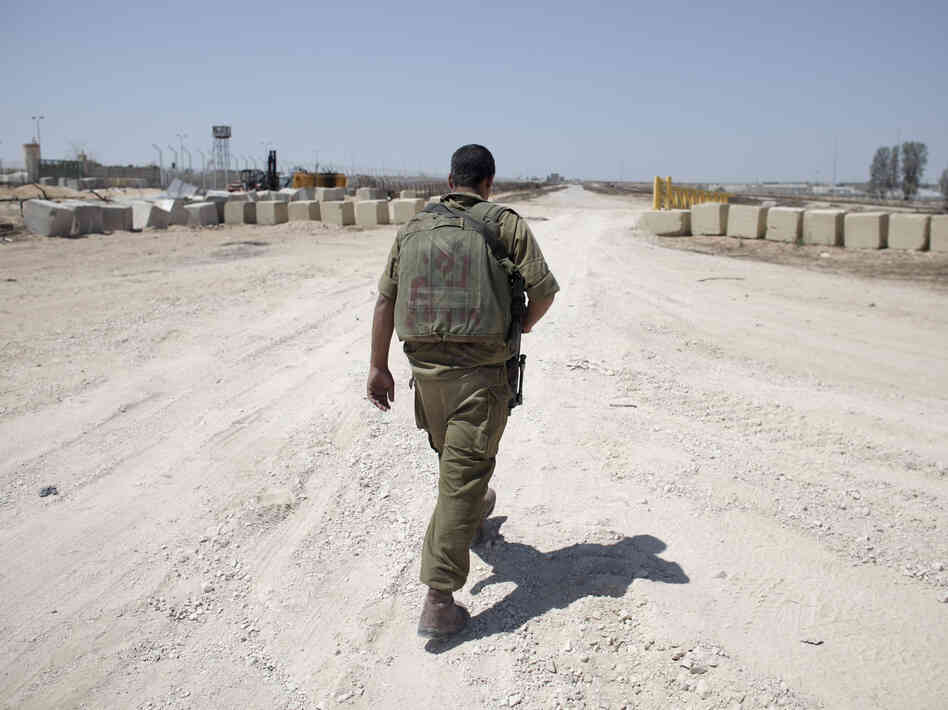 An Israeli soldier walks near the border between Israel and Egypt at the Kerem Shalom border crossing on Wednesday.