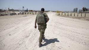 An Israeli soldier walks near the border between Israel and Egypt at the Kerem Shalom border crossing on Wednesday.