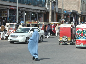 A woman crosses the street in Herat, Afghanistan. Burqa-clad women stand out on the streets in Afghanistan ΓΆ€” both because of their bright blue burqas, and because there are far fewer women in public than men. A woman crosses the street in Herat, Afghanistan. Burqa-clad women stand out on the streets in Afghanistan ΓΆ€” both because of their bright blue burqas, and because there are far fewer women in public than men.