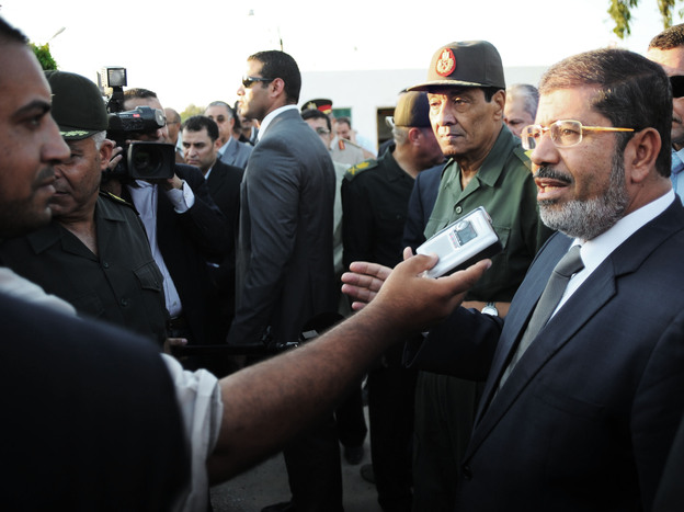 Egyptian President Mohammed Morsi (right) speaks to the media on Aug. 6 in El Arish, Egypt. He has already been engaging with the public more regularly than his predecessor.