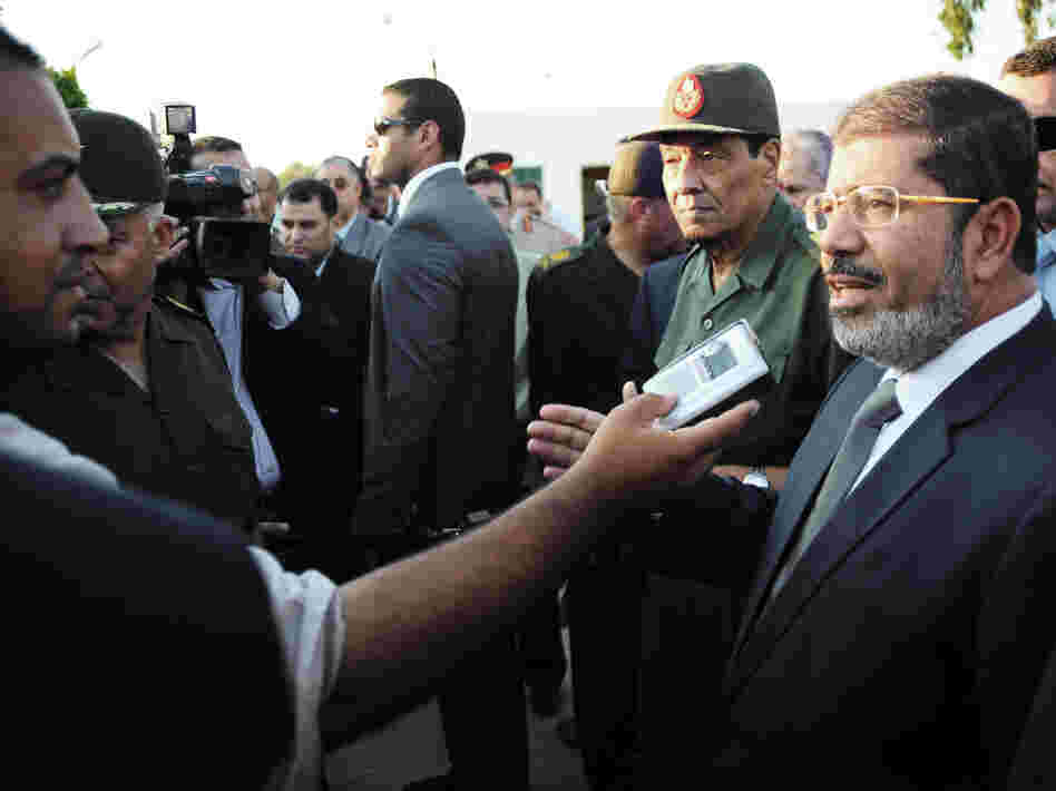 Egyptian President Mohammed Morsi (right) speaks to the media on Aug. 6 in El Arish, Egypt. He has already been engaging with the public more regularly than his predecessor.