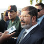 Egyptian President Mohammed Morsi (right) speaks to the media on Aug. 6 in El Arish, Egypt. He has already been engaging with the public more regularly than his predecessor.