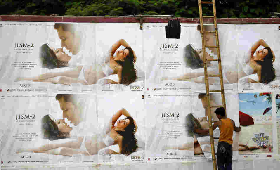 A man pastes the posters of Bollywood film "Jism 2" outside a cinema hall in Bangalore, India.