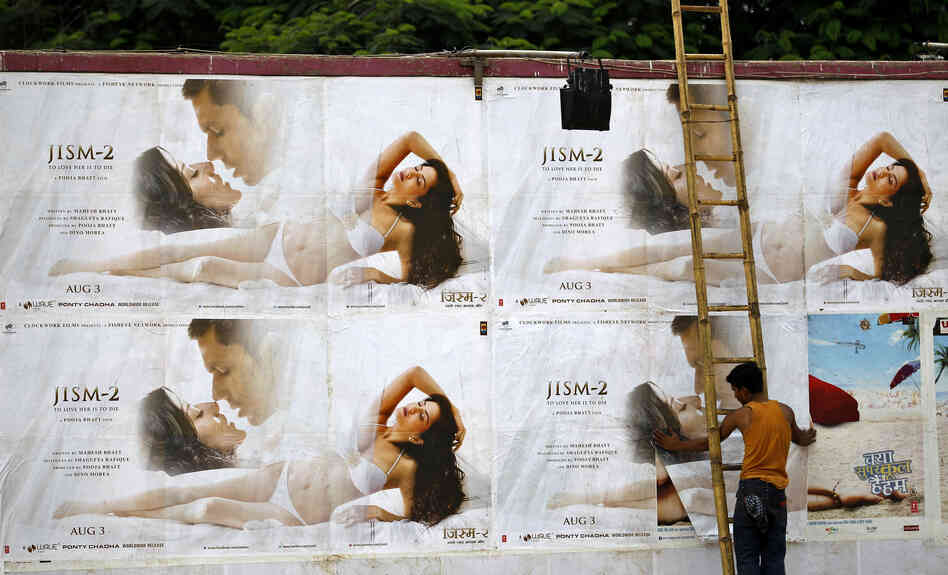 A man pastes the posters of Bollywood film "Jism 2" outside a cinema hall in Bangalore, India.