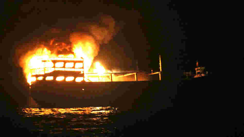 The burning dhow from which the U.S. Navy says it rescued 10 Iranians on Wednesday in the Gulf of Oman.
