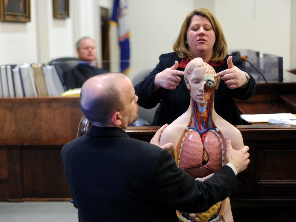 Dr. Amy Tharp, a forensic pathologist, explains gun shot wounds on an anatomical model during her testimony in Bedford, Va. in March 2010.