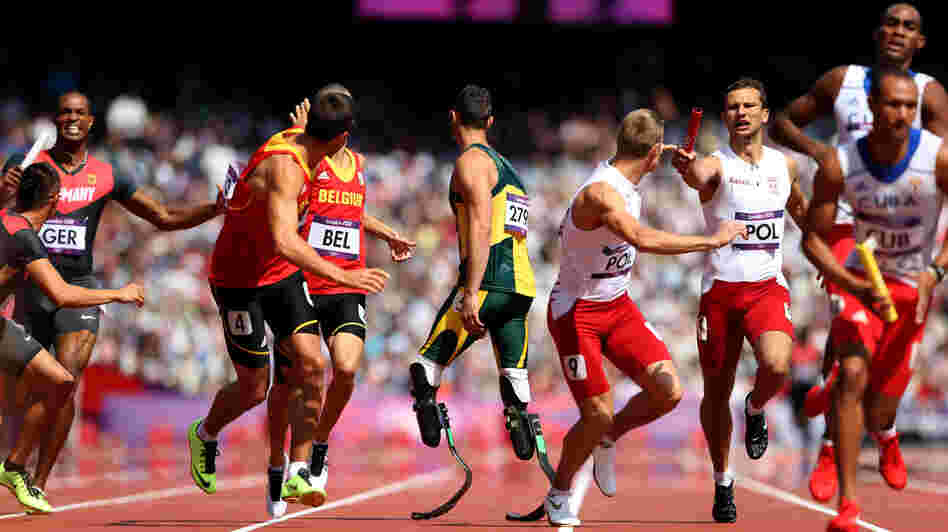 Anticipation: Oscar Pistorius of South Africa waits for the baton in the team 4x400m relay at London's Olympic Stadium. His teammate fell in the race, but officials deemed he had been interfered with. South Africa will run in the final.